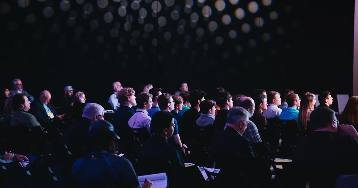 Crowd watching a live competition event with a large display screen