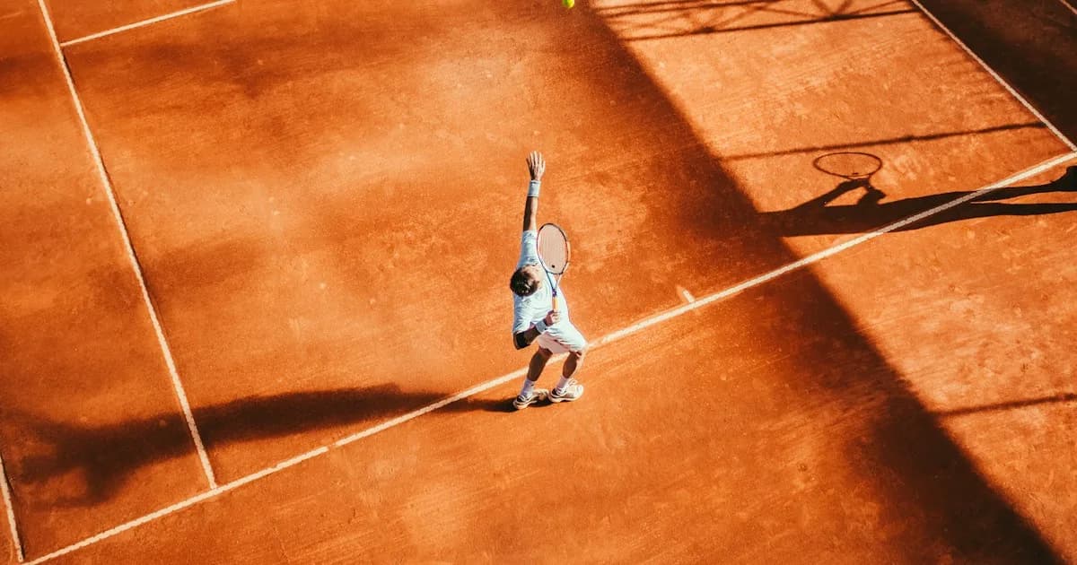 Tennis player serving on a clay court