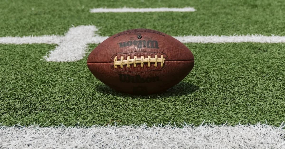 American football on a field, representing fantasy football standings stats