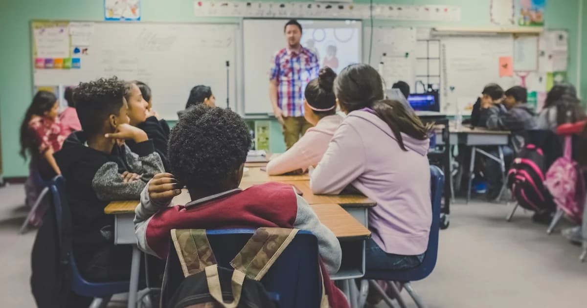 Teacher working with students at a desk in a bright classroom