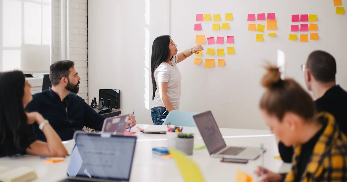 Sales team reviewing performance numbers on a wall-mounted display